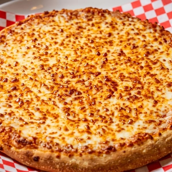 A freshly baked cheese pizza with a golden crust sits on red and white checkered paper.